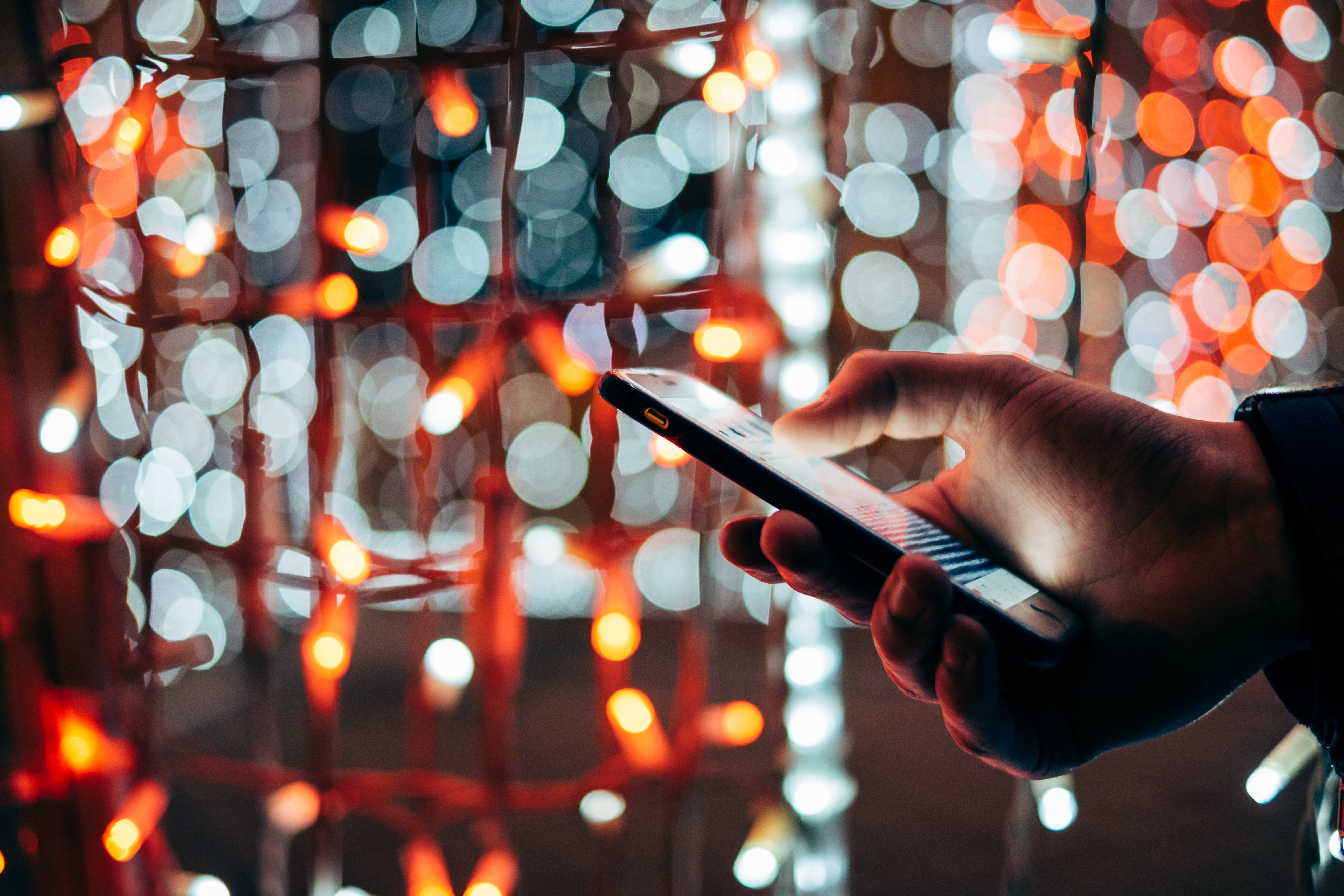 man-using-mobile-device-at-colorful-light-background_t20_29y3yP